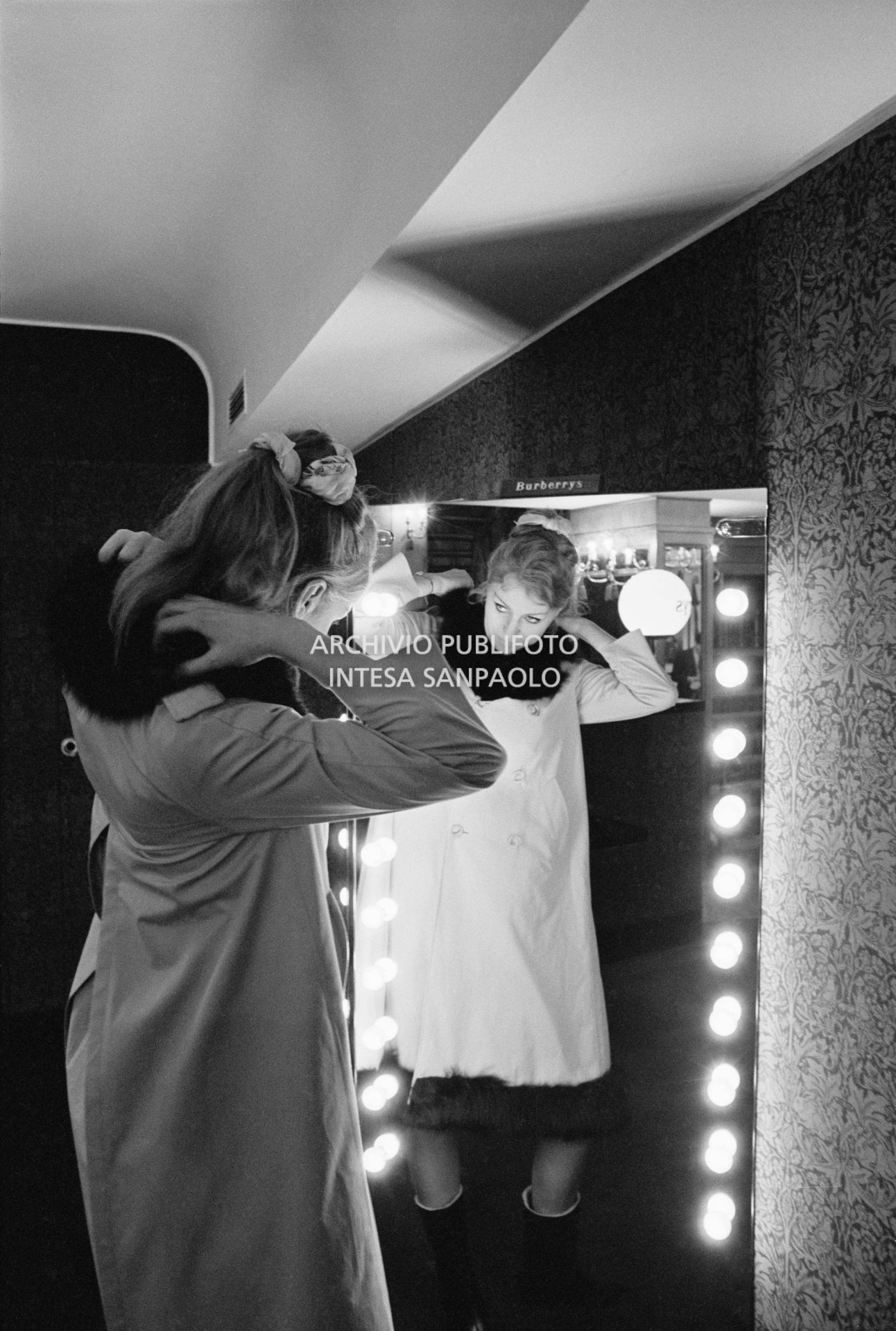 Anna German, con indosso un trench con l'interno in pelliccia, si specchia al negozio Burberrys'<br>727771/14