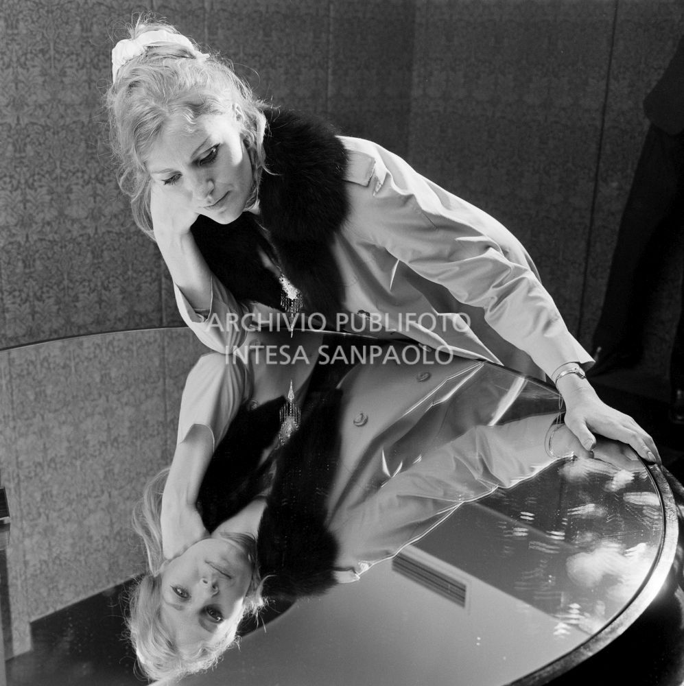 Anna German, con indosso un trench con l'interno in pelliccia, si specchia in un tavolino al negozio Burberrys'<br>727771/39