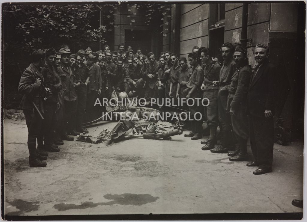 Militari in posa intorno ai rottami di un aereo abbattuto