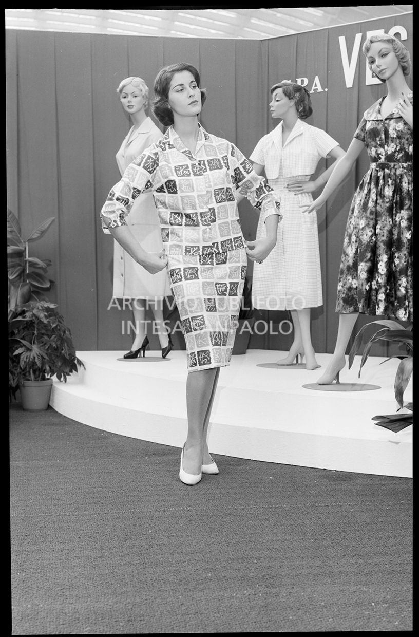 Indossatrice con tailleur con ideogrammi giapponesi e sullo sfondo tre manichini<br>21834bis