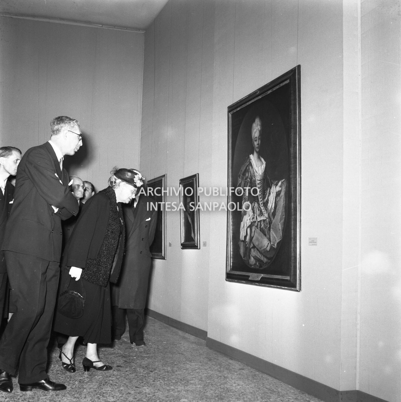 Ida Pellegrini, moglie del presidente della Repubblica Luigi Einaudi, ammira un quadro della mostra "Pittori della realtà in Lombardia" a Palazzo Reale a Milano, in compagnia, tra gli altri, di Gian Alberto Dell'Acqua<br>162142