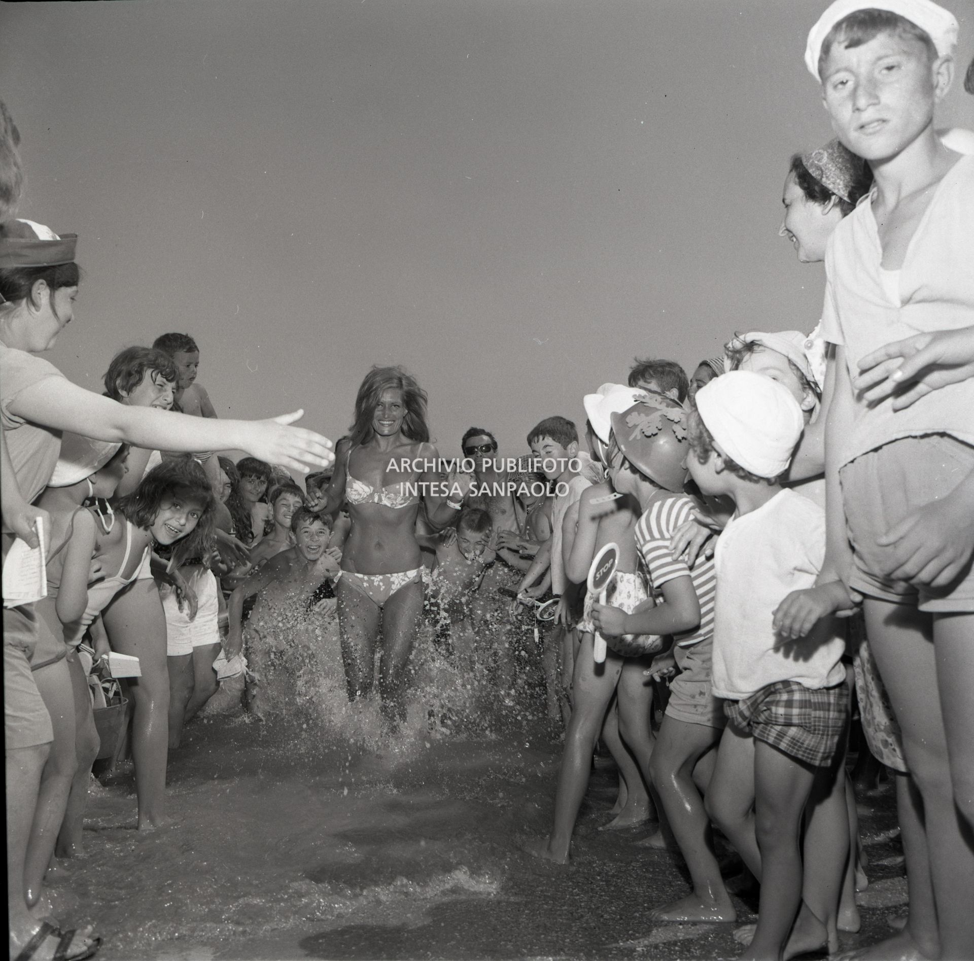 Dalida esce dal mare in bikini, tra due ali di folla, durante uno degli spostamenti del VII Cantagiro, in occasione del quale interpretò la canzone "Un po' d'amore".