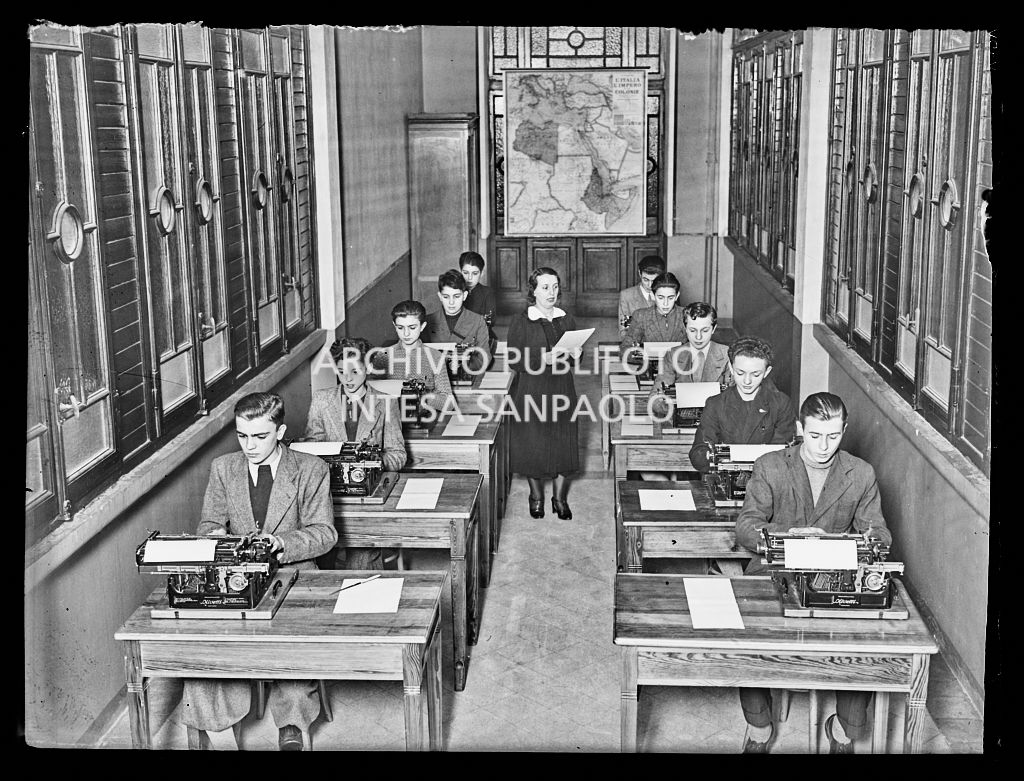 Ragazzi, seduti al banco, durante una lezione di dattilografia