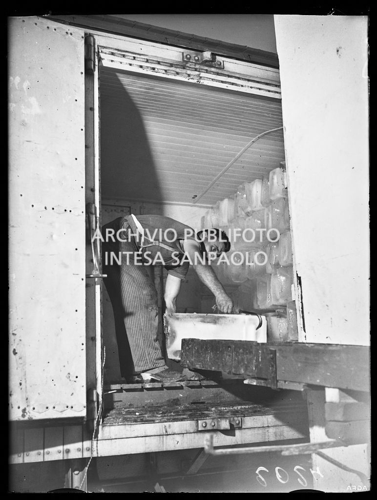 Un uomo carica un blocco di ghiaccio su un furgone