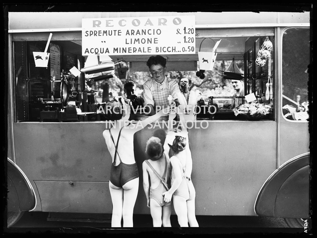 Tre bambini acquistano un gelato dal furgone di un venditore ambulante di bibite e gelati