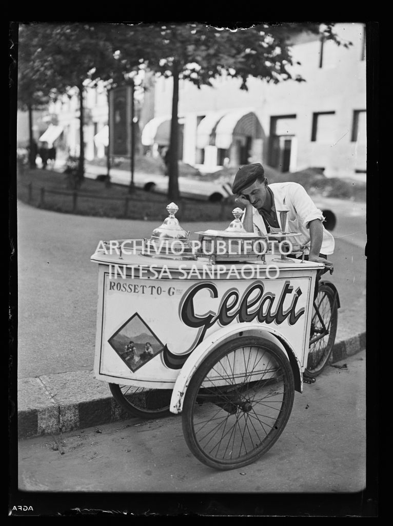 Un gelataio ambulante si riposa appoggiato al carretto per la vendita