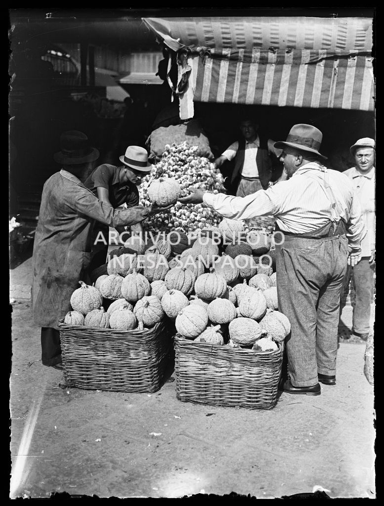 Vendita di ortaggi; in primo piano due ceste colme di zucche