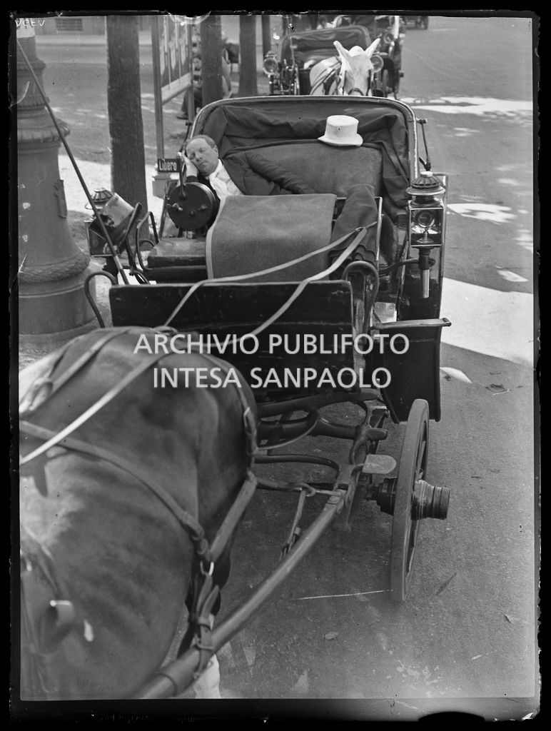 Un cocchiere addormentato su una carrozza in sosta in un parco