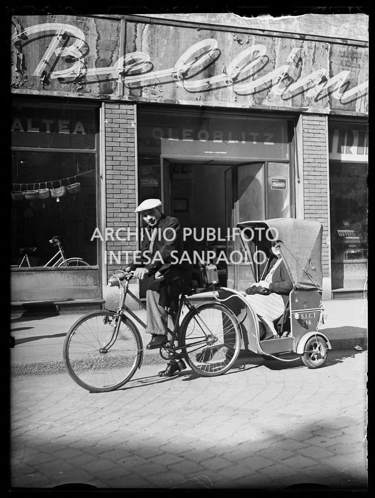 Un autista del servizio di taxi con bicicletta S.I.C.T. di Milano trasporta una cliente