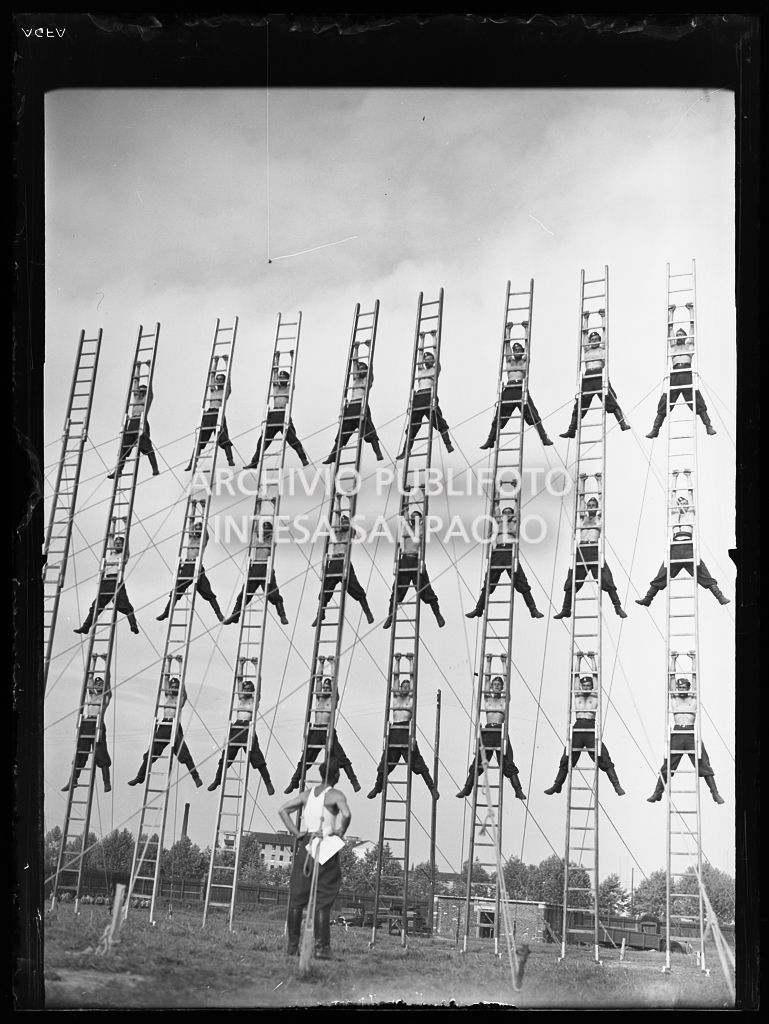 Pompieri in posa acrobatica, su scale a pioli, durante un'esercitazione