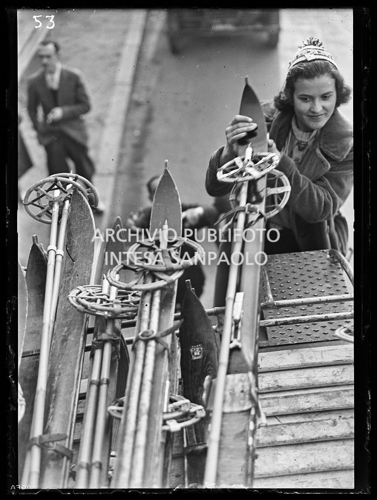 Una ragazza sistema gli sci sul tetto di un pullmann