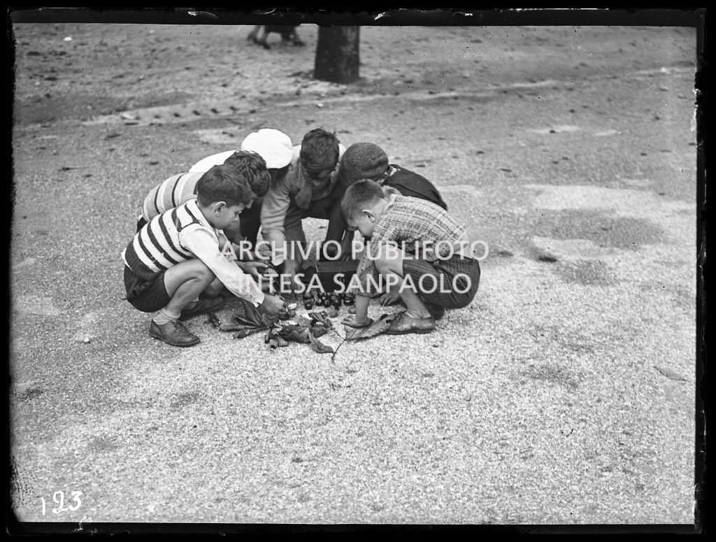Un gruppo di bambini gioca con delle castagne selvatiche, in un parco
