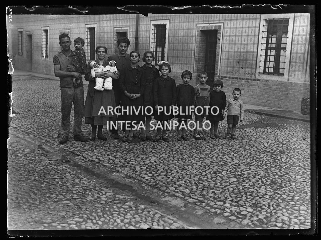 Una coppia, con undici figli, ritratta in un cortile