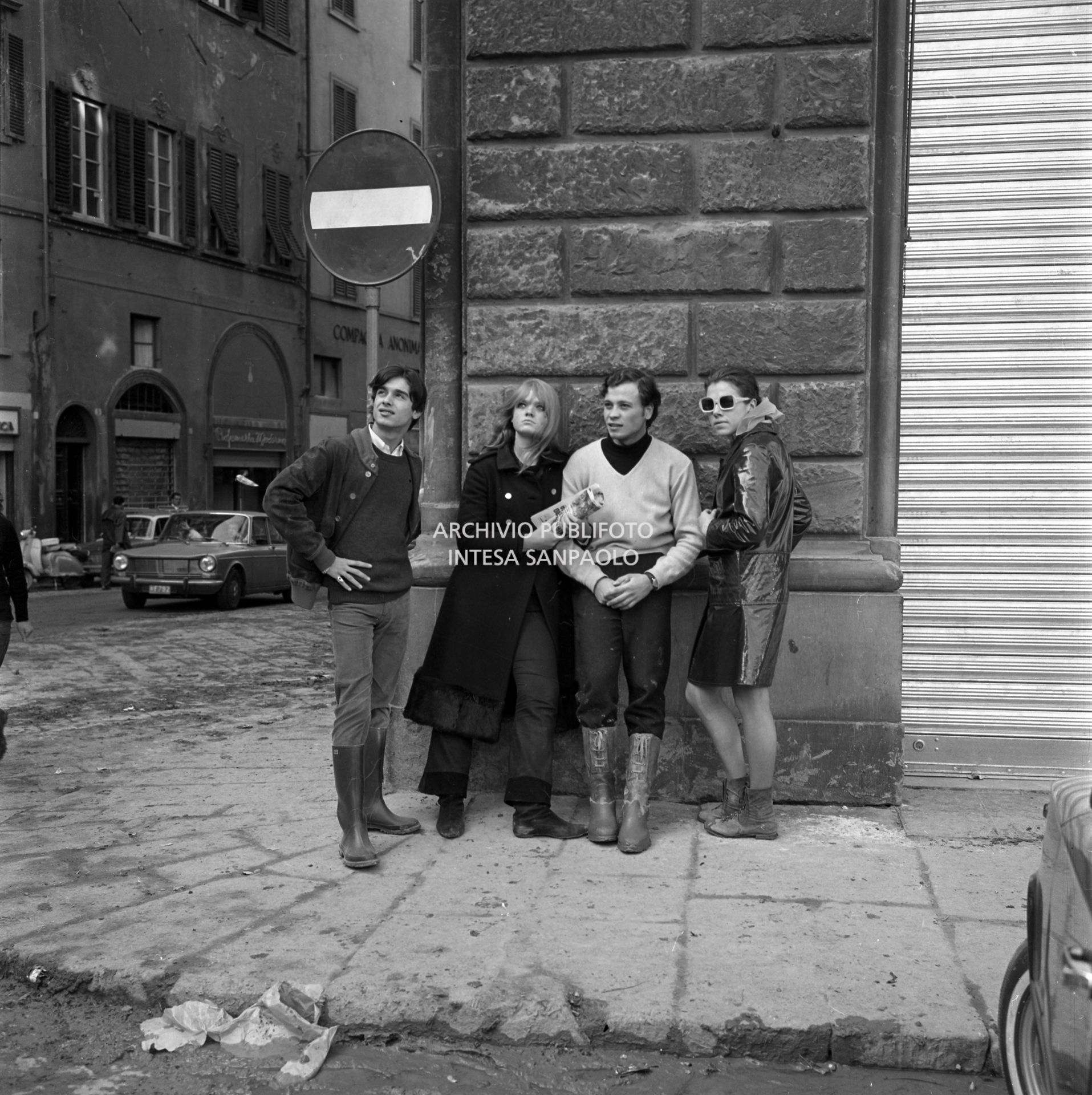 Giovani in posa in una via di Firenze dopo lo straripamento del fiume Arno
