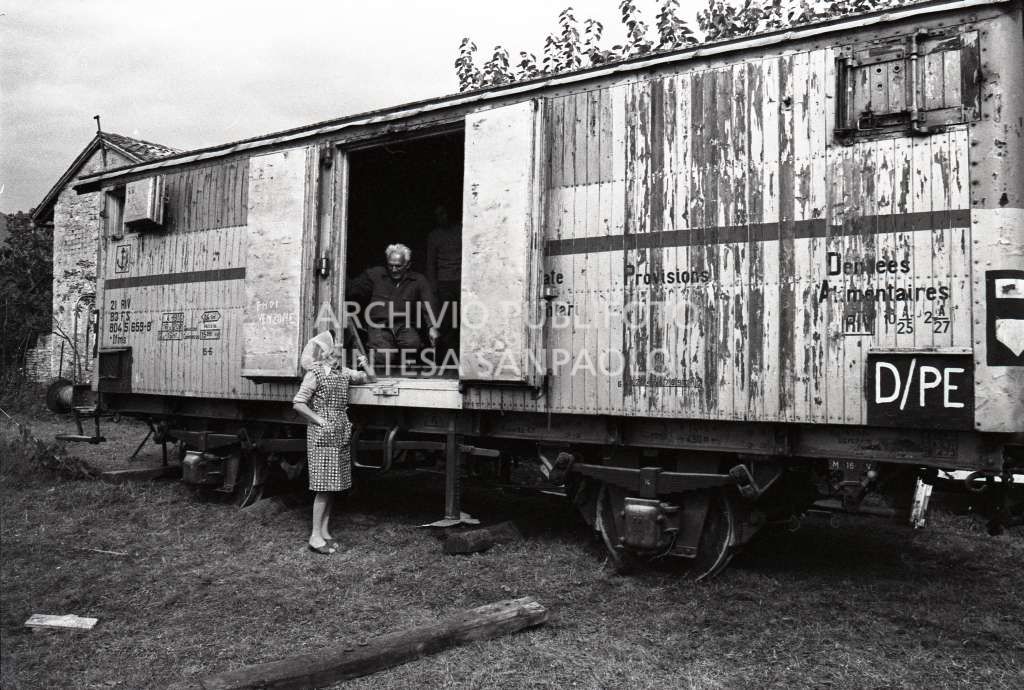 Un uomo parla con una donna da un vagone ferroviario in una delle città colpite dal terremoto del Friuli