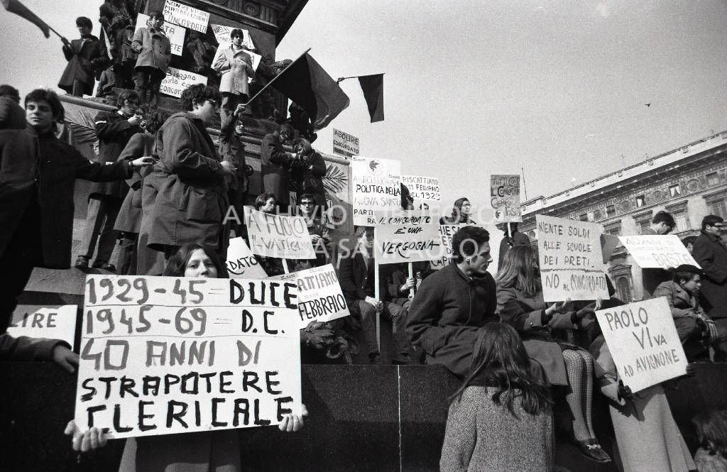 Studenti, con cartelli di protesta contro il Concordato Stato/Chiesa, sul monumento a Vittorio Emanuele II in piazza Duomo a Milano<br>730611/26