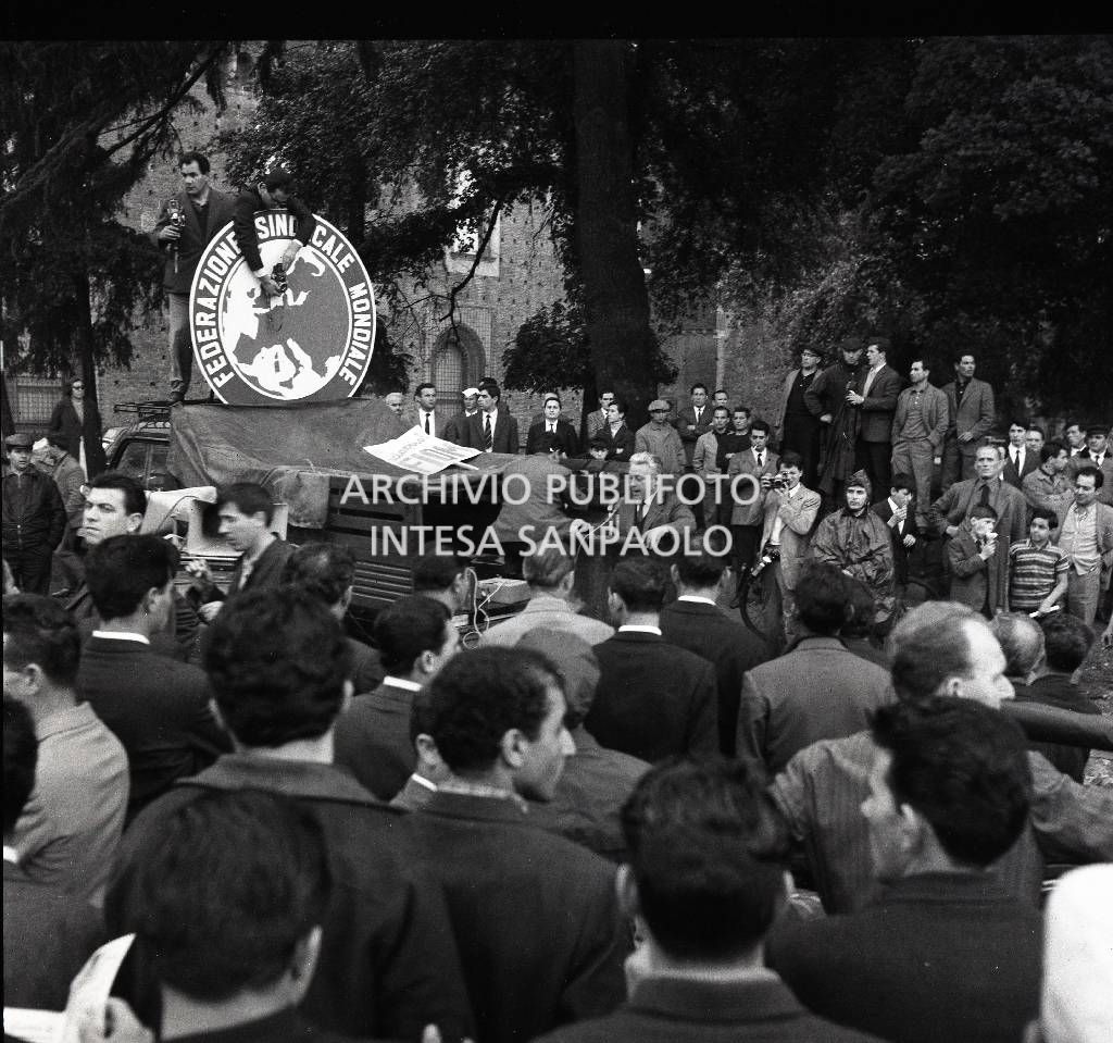 Sciopero CGIL: folla di lavoratori, in piazza del Cannone a Milano, ascolta i comizi alla conclusione della manifestazione; a sinistra il simbolo della "Federazione sindacale mondiale".<br>723176/9