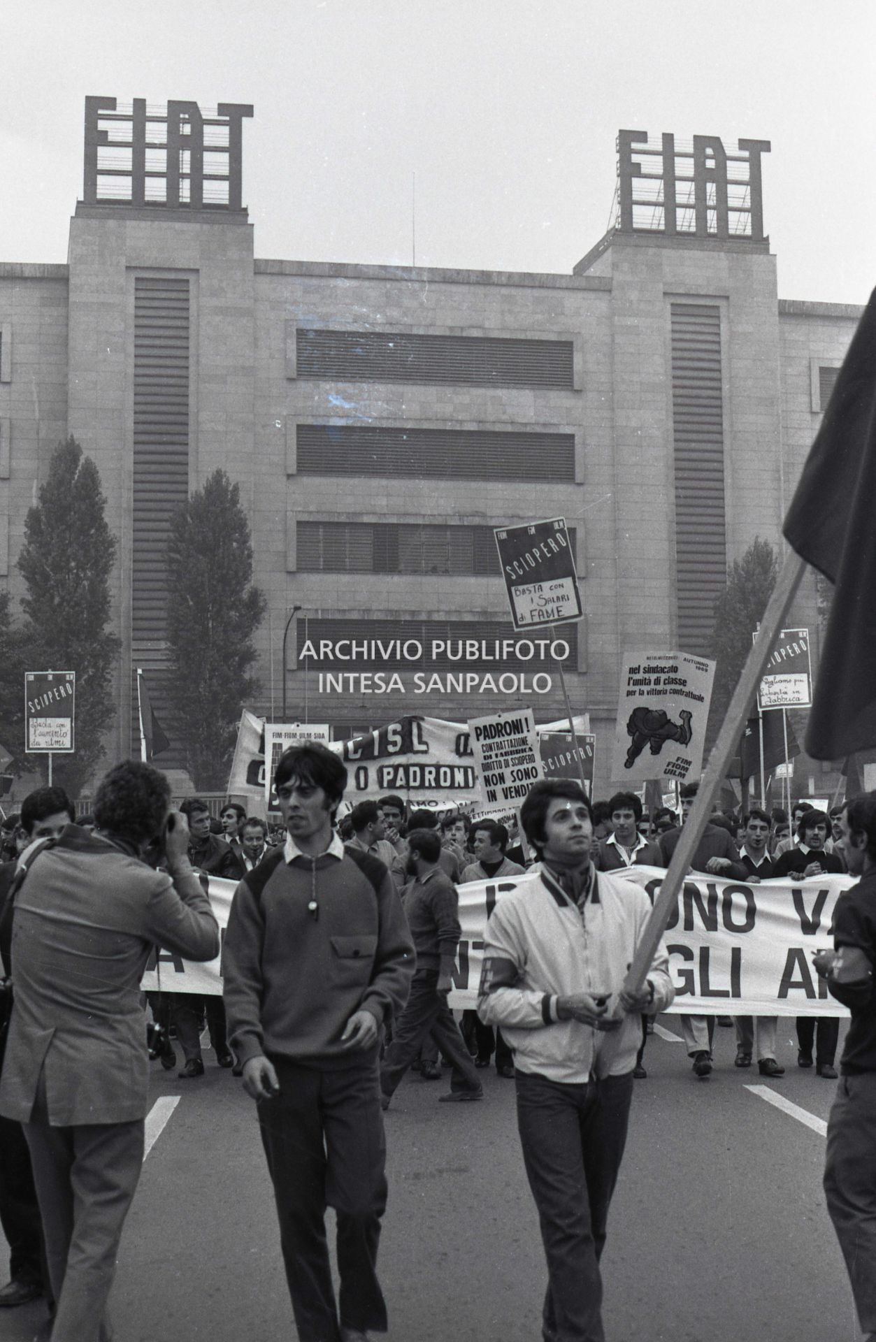 Operai in sciopero, davanti allo stabilimento Fiat Mirafiori, in corso Traiano a Torino, con cartelli, striscioni e bandiere