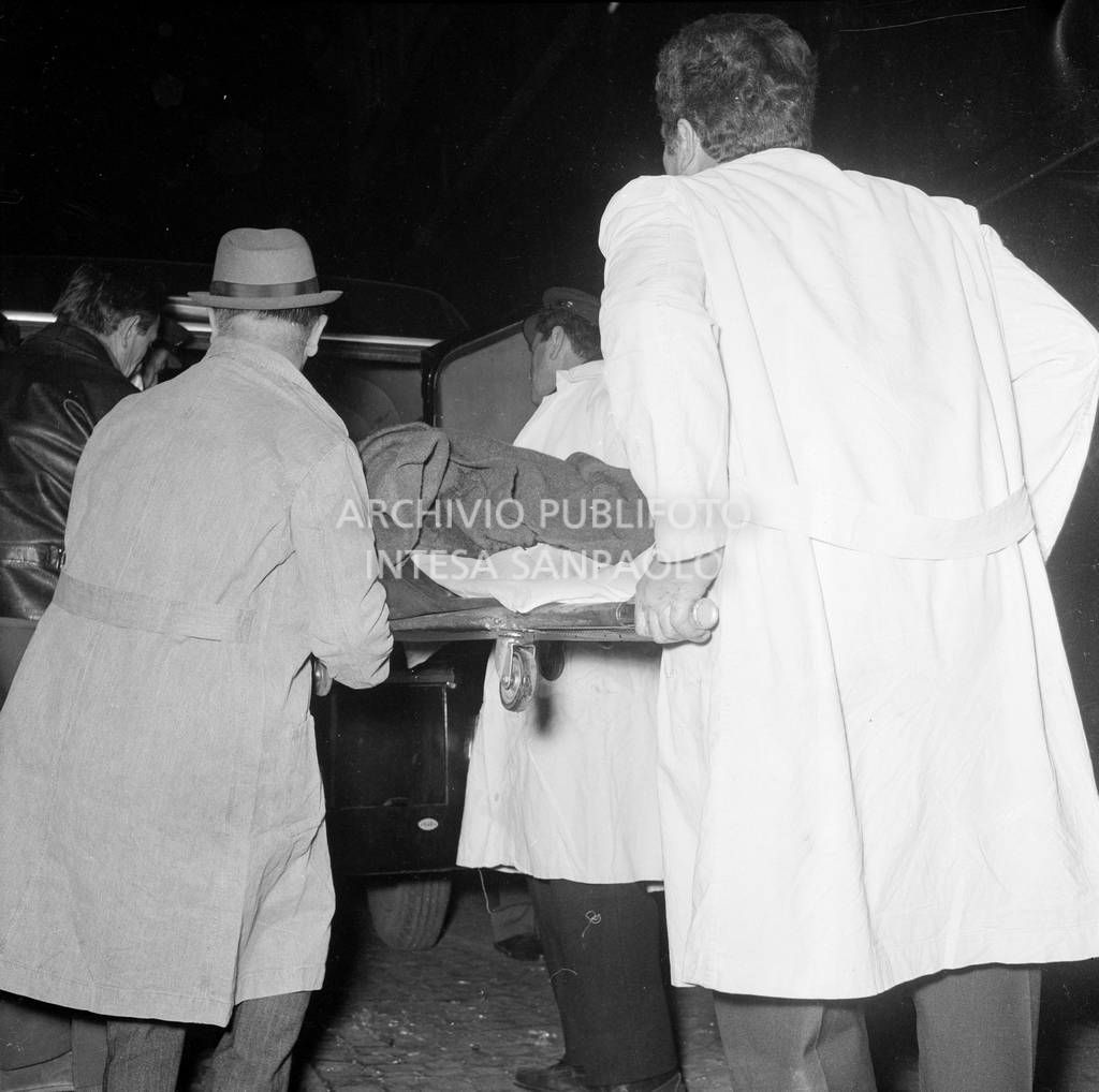 La salma di una vittima mentre viene caricata sul carro funebre<br>731743/45