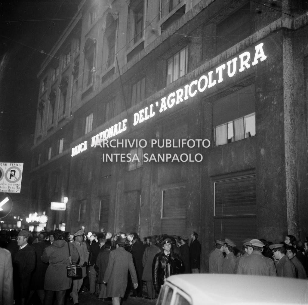 Forze dell'ordine, giornalisti e cittadini davanti alla Banca Nazionale dell'Agricoltura, in piazza Fontana a Milano, il giorno della strage