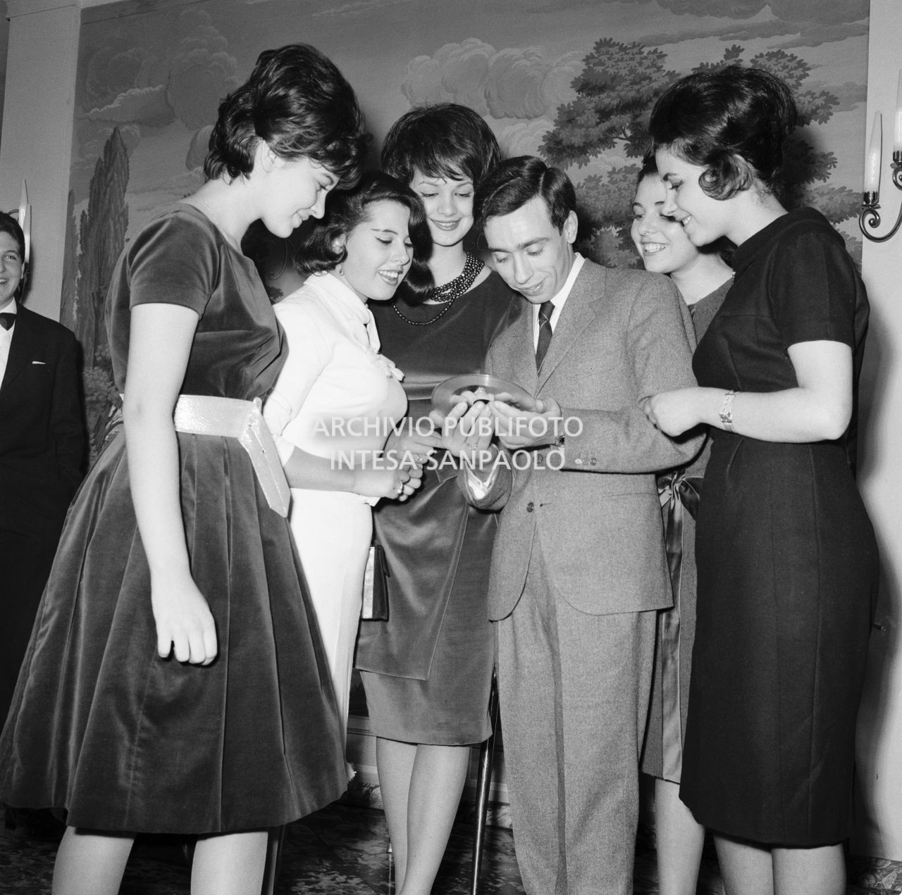 Umberto Bindi, circondato da numerose donne ammira il Disco d'Oro appena ricevuto<br>696393