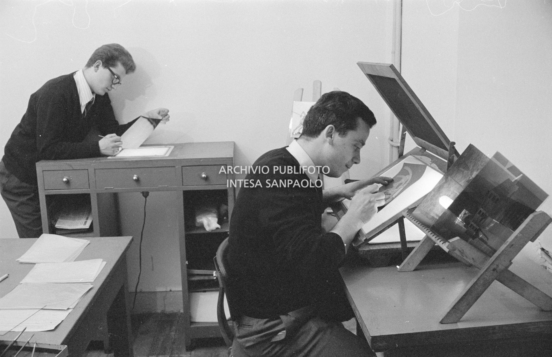 Nicola D'Alessio (a destra) alla postazione dedicata al ritocco delle fotografie e dei negativi nella sede dell'agenzia Publifoto in via Bramante a Milano