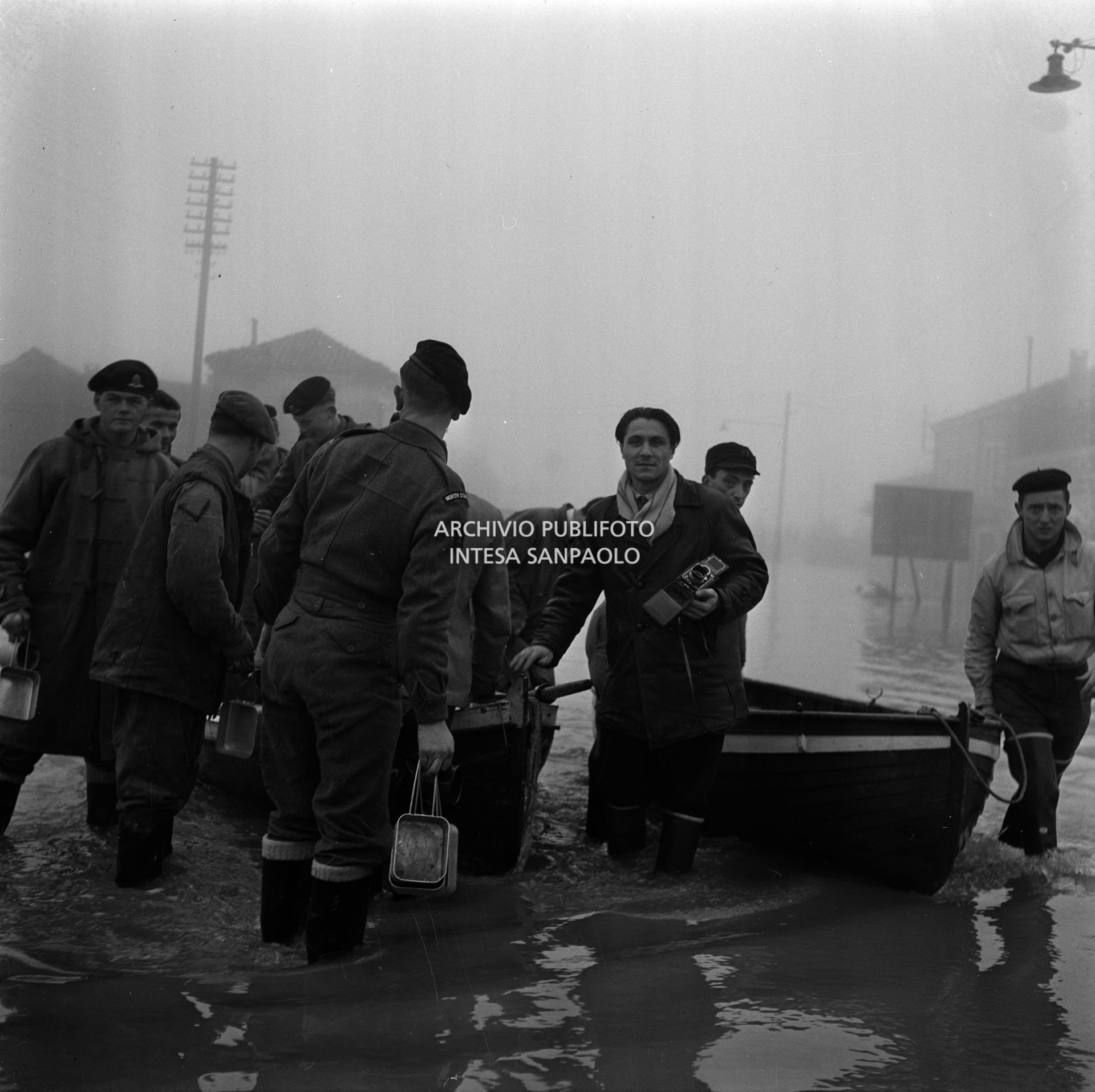 Il fotoreporter Tino Petrelli, con la sua macchina fotografica, durante l'alluvione del Polesine, a Corbola