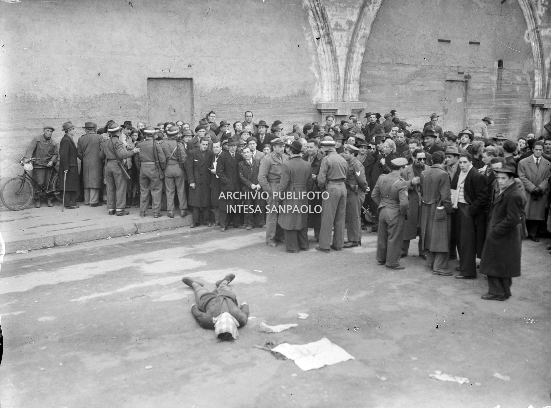 Folla di curiosi e forze dell'ordine vicino al corpo esanime di Sandro Bezzi, ucciso a Milano dalla polizia dopo un conflitto a fuoco con i banditi