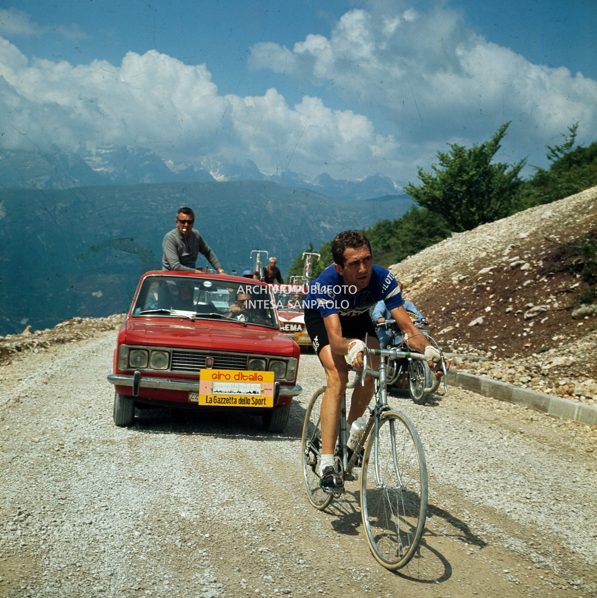 Italo Zilioli durante una tappa del 51° Giro d'Italia; lo seguono un'automobile degli organizzatori con la scritta della Gazzetta dello Sport e l'ammiraglia della Faema