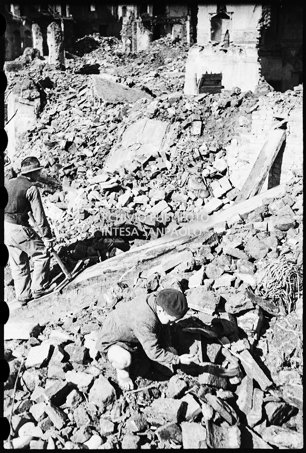 Un ragazzino e un uomo con piccone tra le macerie dei bombardamenti a Pavia<br>26654