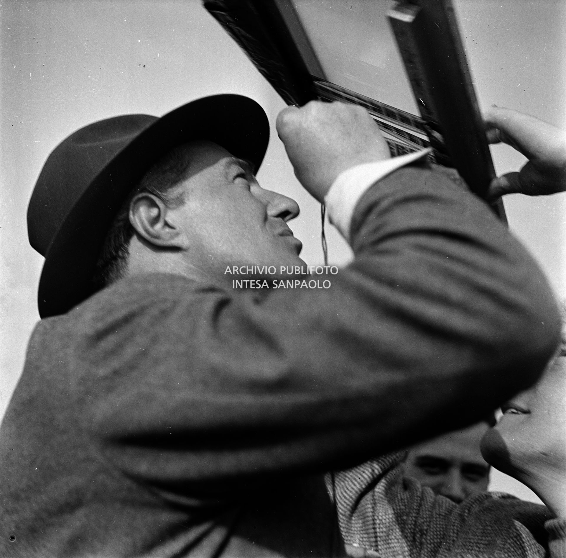 Il regista Vittorio De Sica guarda in controluce dei negativi sul set del film "Miracolo a Milano" girato nel quartiere milanese di Lambrate