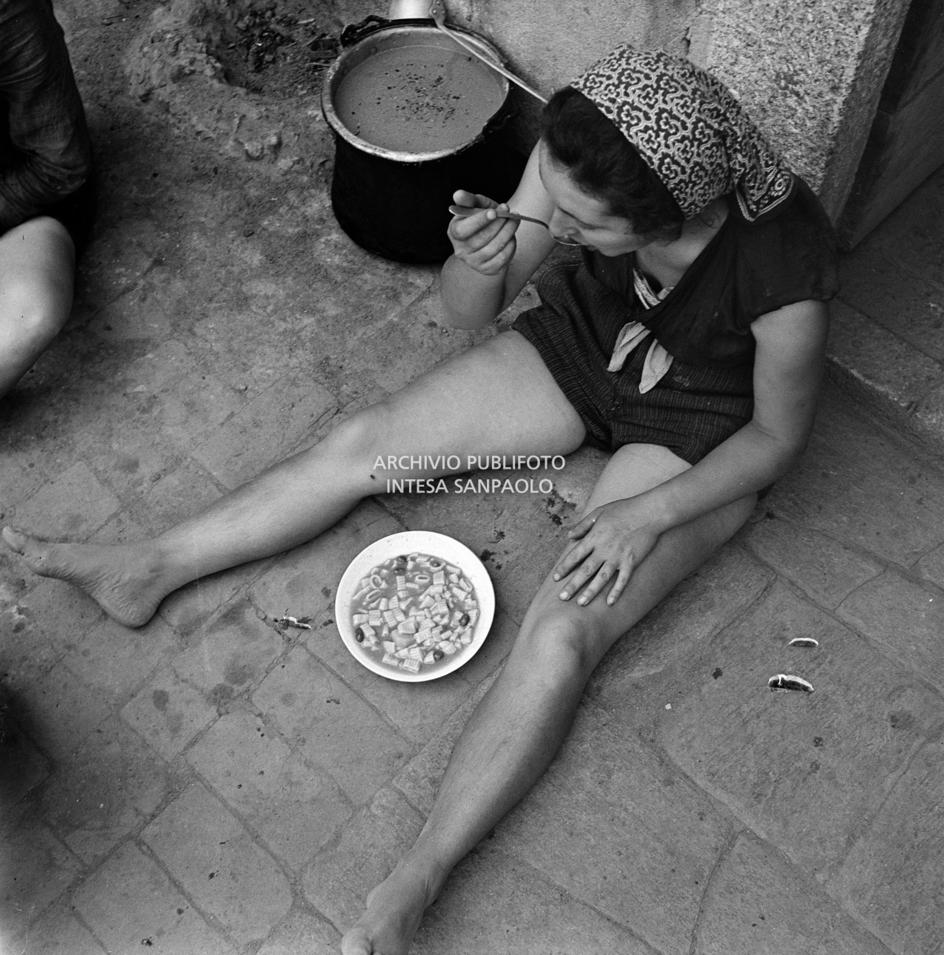 Una mondina pranza durante una pausa dal lavoro nei campi nei dintorni di Binasco