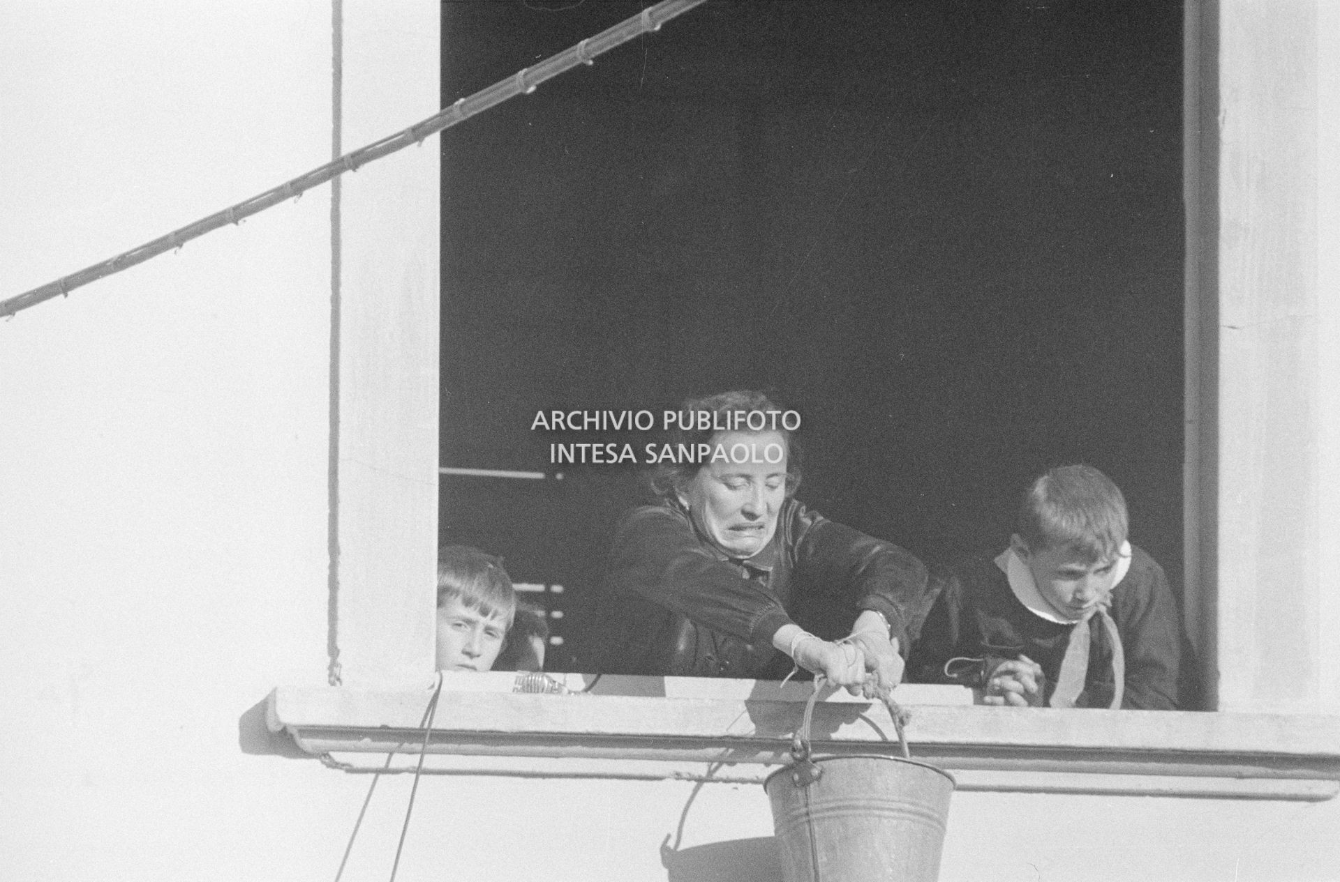 Una maestra della scuola elementare di Terrazzano, frazione di Rho in provincia di Milano, tenuta in ostaggio con altre due colleghe e gli alunni da i due fratelli Santato, recupera alla finestra un secchio con il cibo