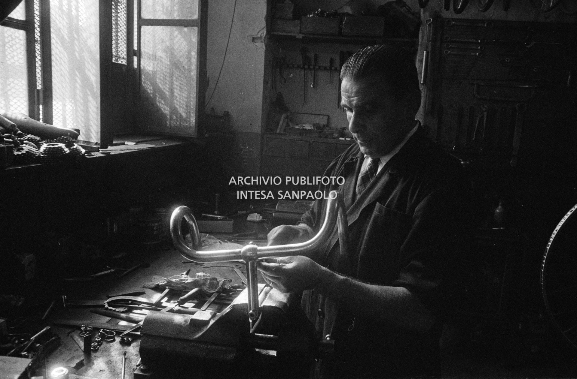 Il meccanico Giuseppe De Grandi, detto Pinella, prepara la bicicletta di Roger Rivière in vista del record dell'ora che il ciclista francese si sarebbe aggiudicato di lì a tre giorni