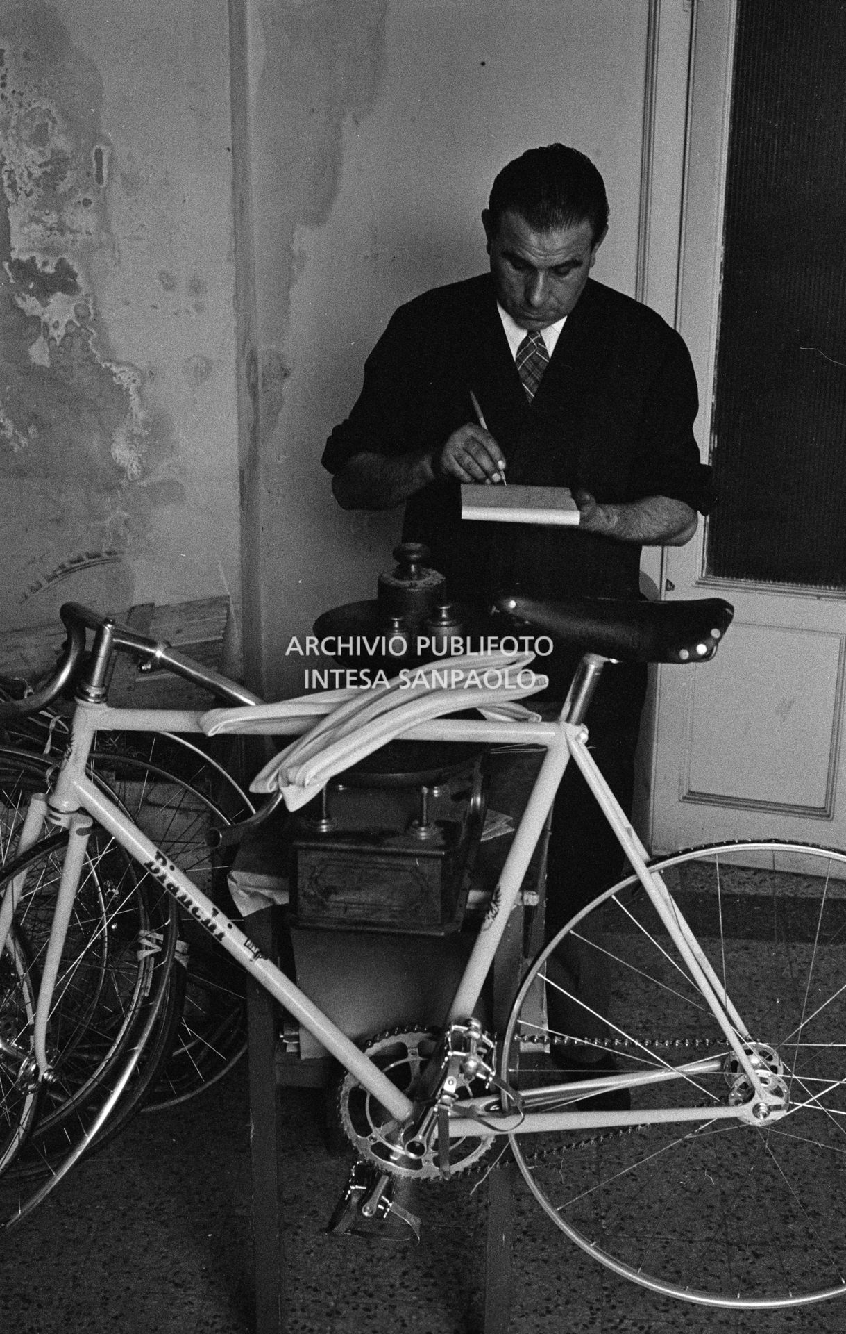 Il meccanico Giuseppe De Grandi, detto Pinella, prepara la bicicletta di Roger Rivière in vista del record dell'ora che il ciclista francese si sarebbe aggiudicato di lì a tre giorni
