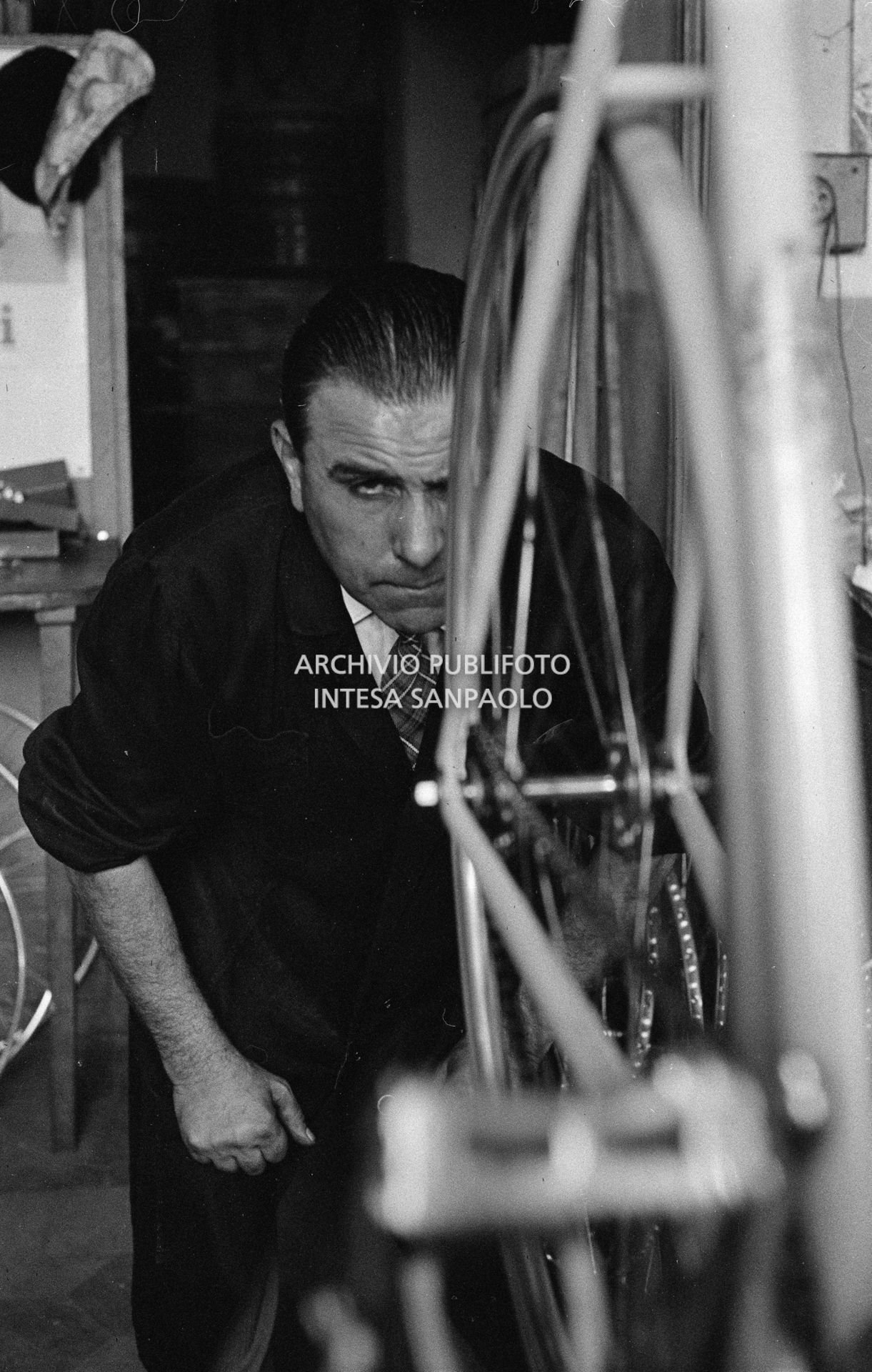 Il meccanico Giuseppe De Grandi, detto Pinella, prepara la bicicletta di Roger Rivière in vista del record dell'ora che il ciclista francese si sarebbe aggiudicato di lì a tre giorni