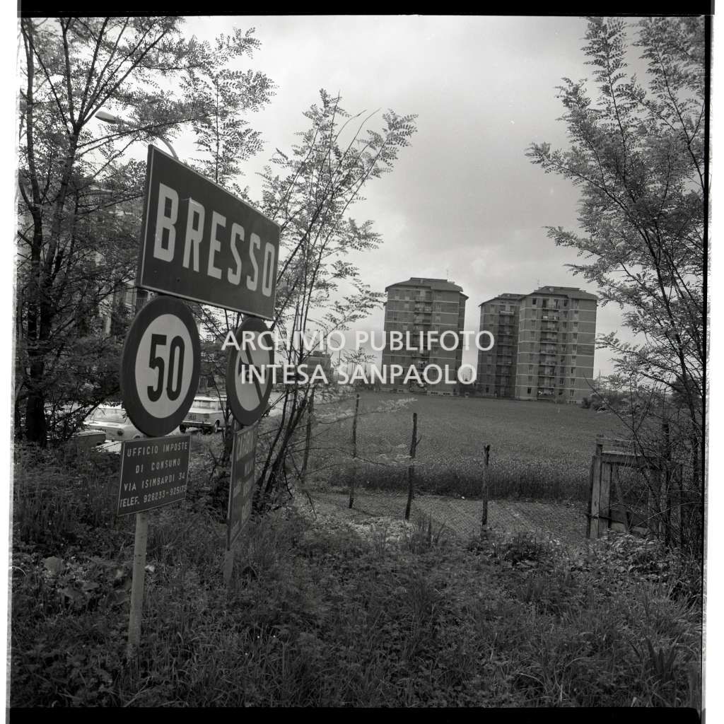 Inizio del territorio di Bresso con segnale di località in primo piano, visibili alcuni palazzi sullo sfondo