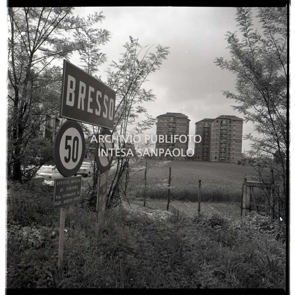 Inizio del territorio di Bresso con segnale di località in primo piano, visibili alcuni palazzi sullo sfondo