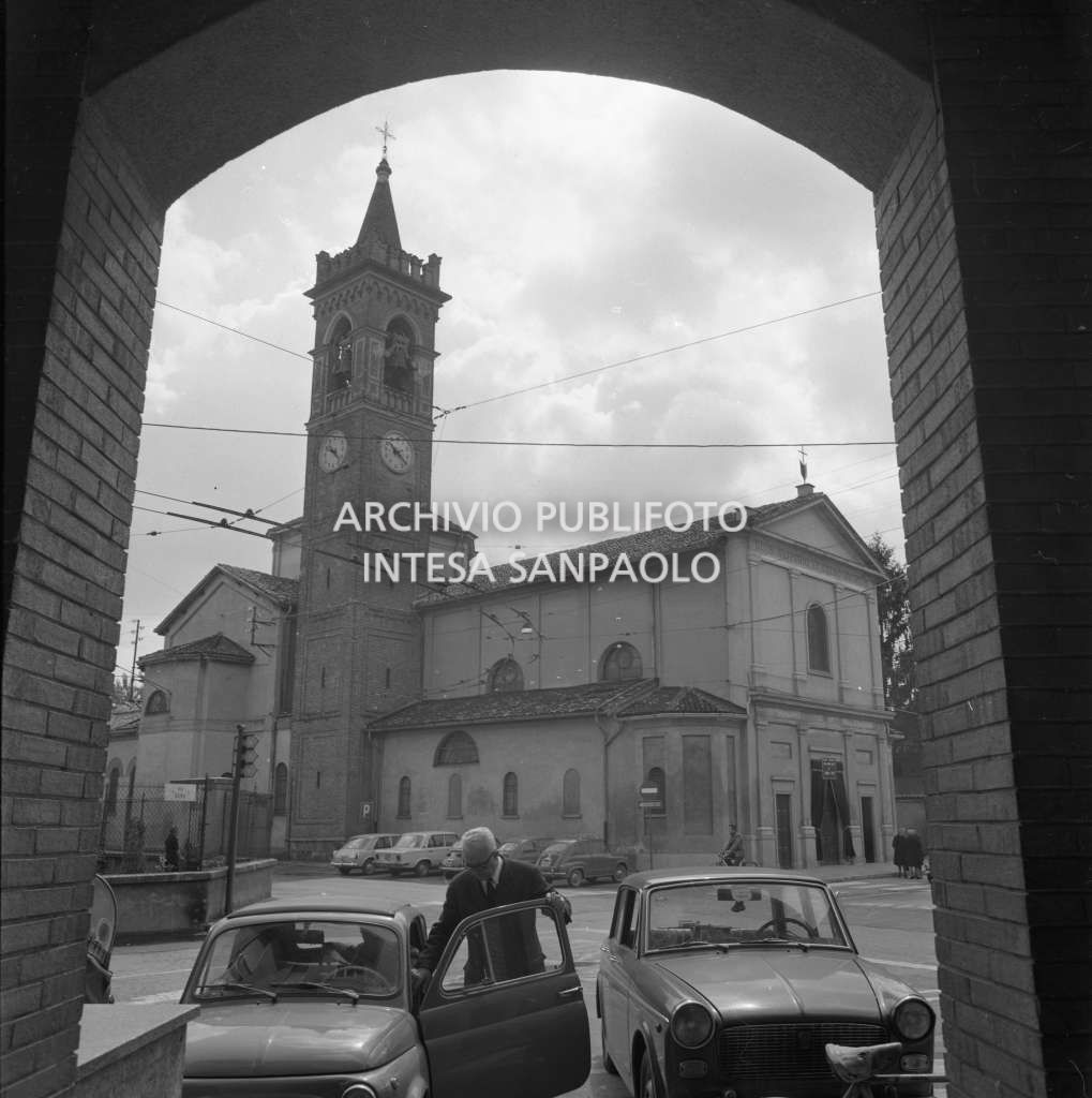 Bresso, la chiesa di San Nazaro e Celso ripresa dall'entrata del Municipio; in primo piano un uomo accanto ad un'automobile