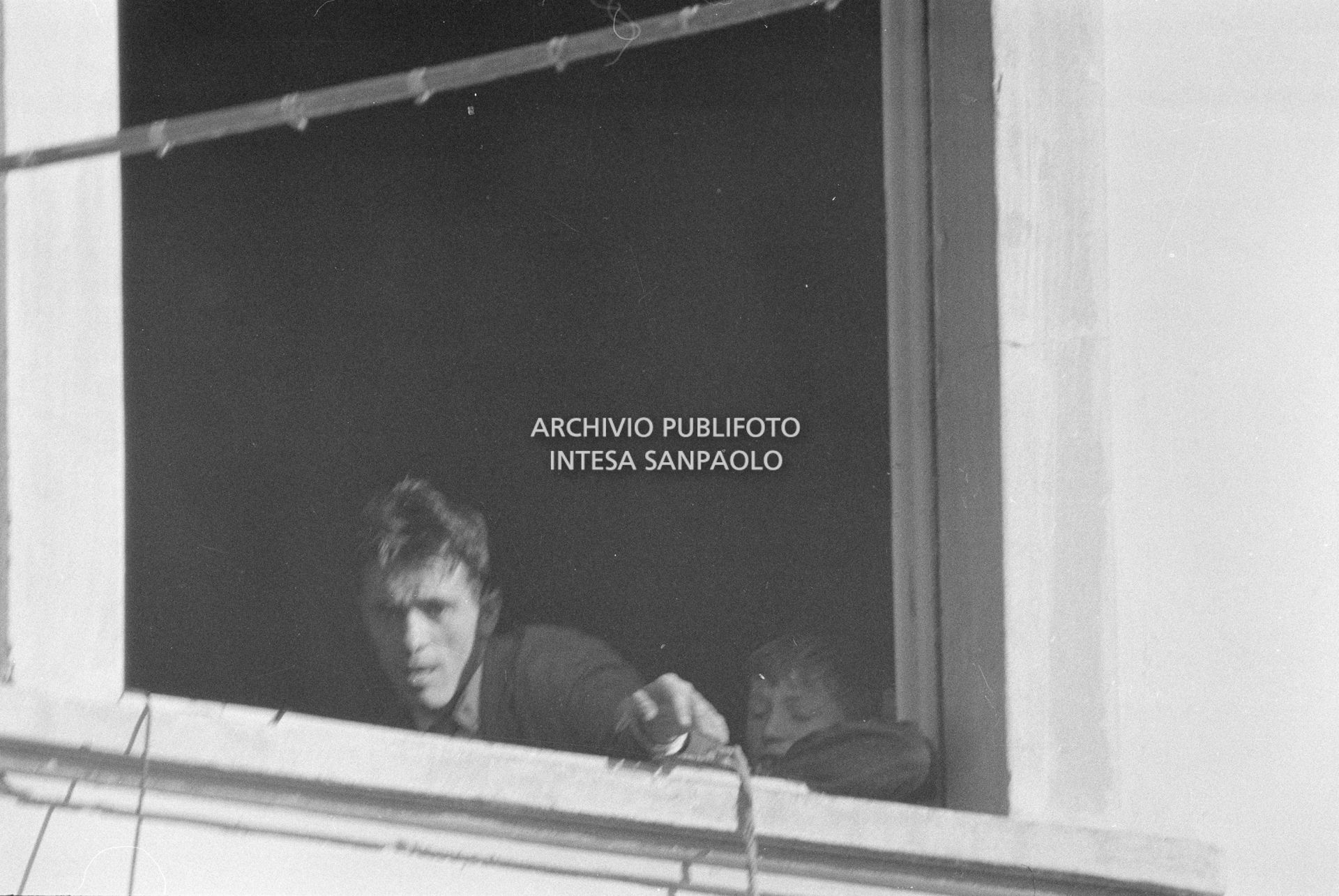 Arturo Santato, parla al microfono, alla finestra della scuola elementare di Terrazzano, frazione di Rho in provincia di Milano, a fianco a una delle maestre che ha sequestrato, insieme agli alunni e ad altre due maestre, con il fratello Egidio