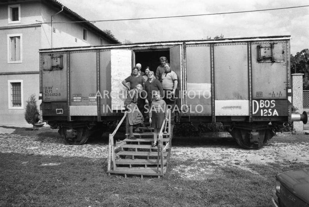 Una famiglia ritratta all'entrata del vagone ferroviario adibito ad abitazione in una delle località colpita dal terremoto in Friuli