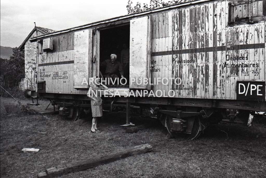 Un uomo parla con una donna da un vagone ferroviario in una delle città colpite dal terremoto del Friuli