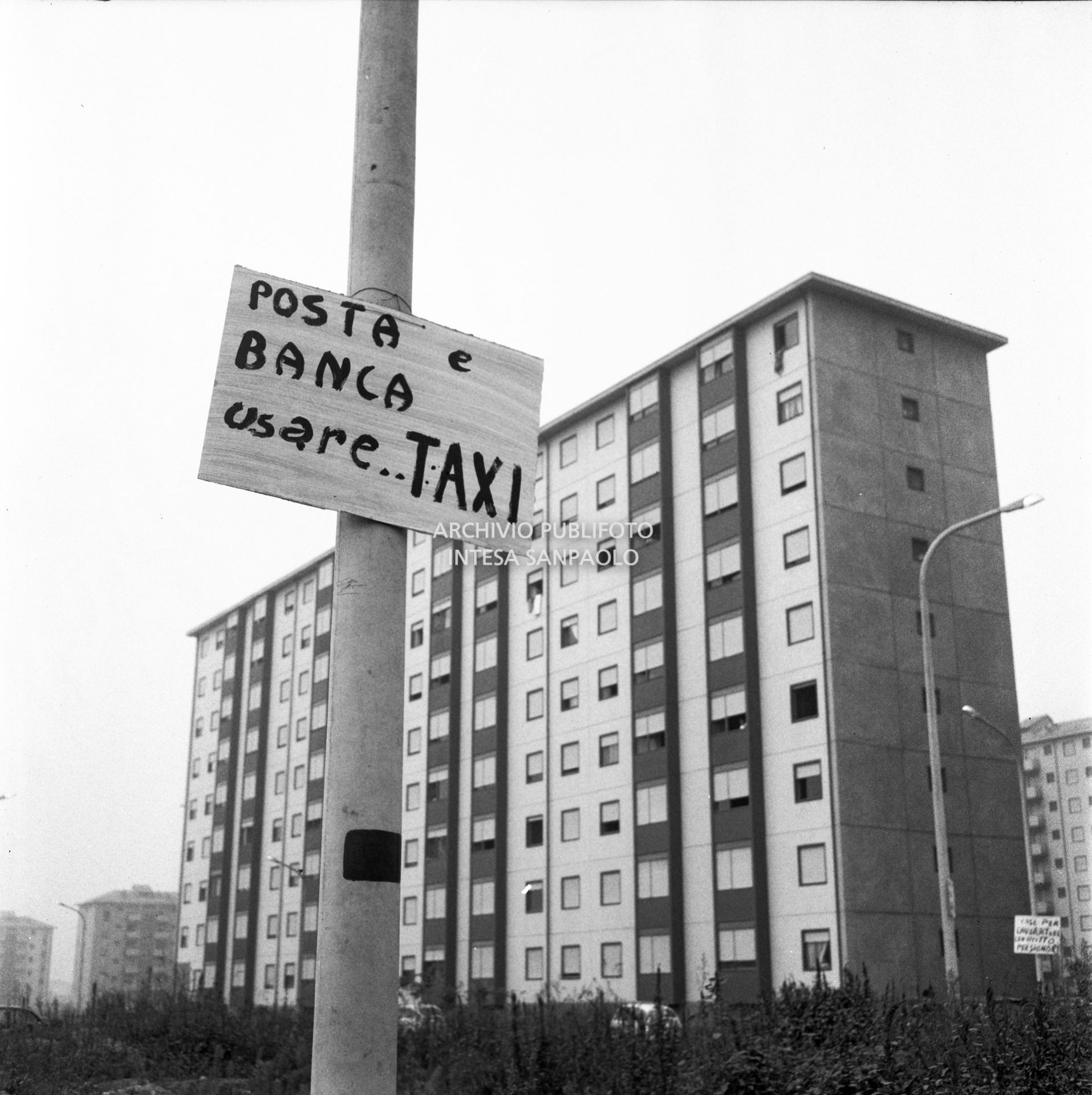 Cartello di denuncia per la mancanza di servizi bancari e postali nel nuovo quartiere Gallaratese