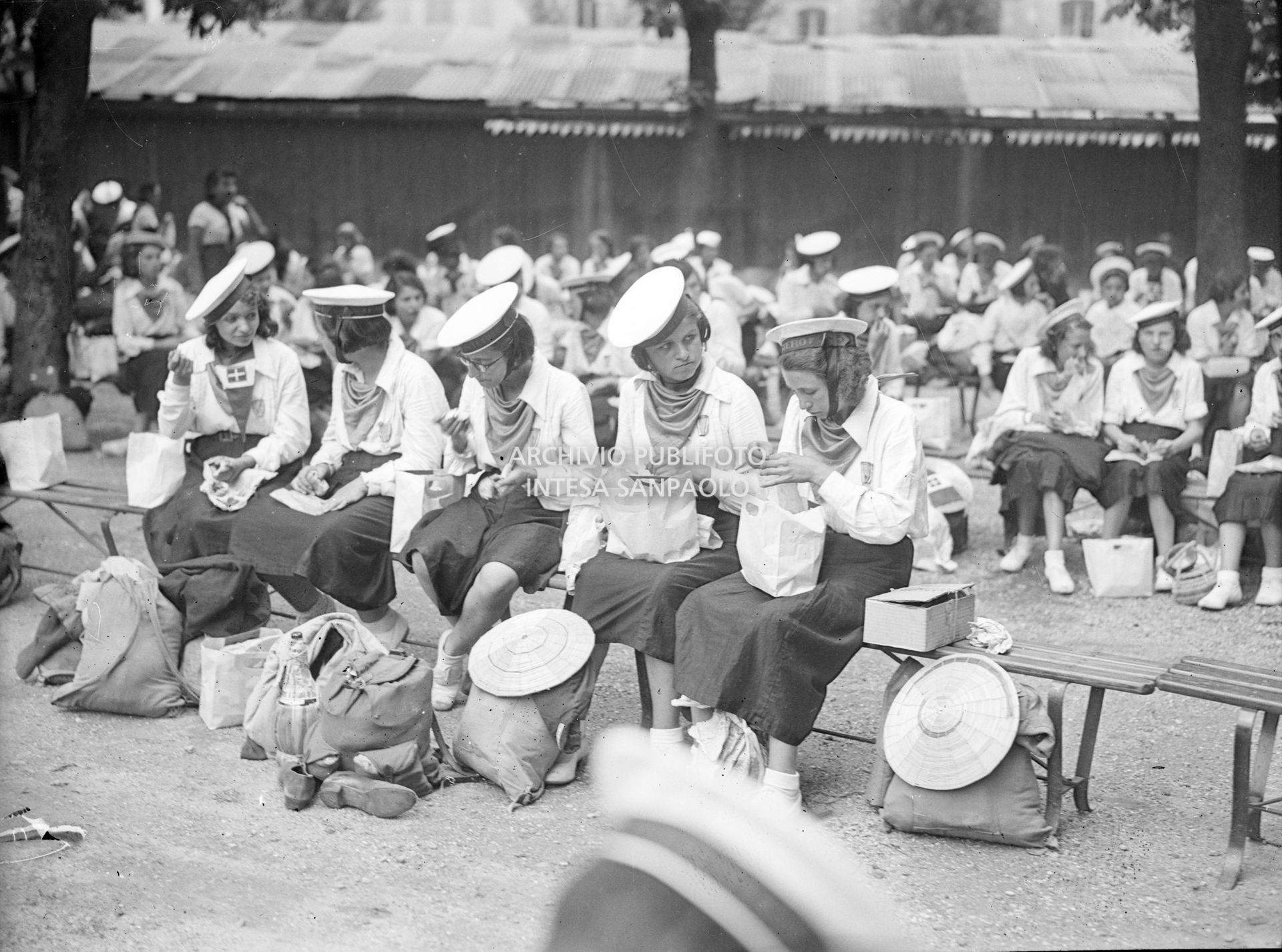 Ragazze della Gioventù italiana del Littorio (GIL), con divisa marinara, consumano il pranzo al sacco