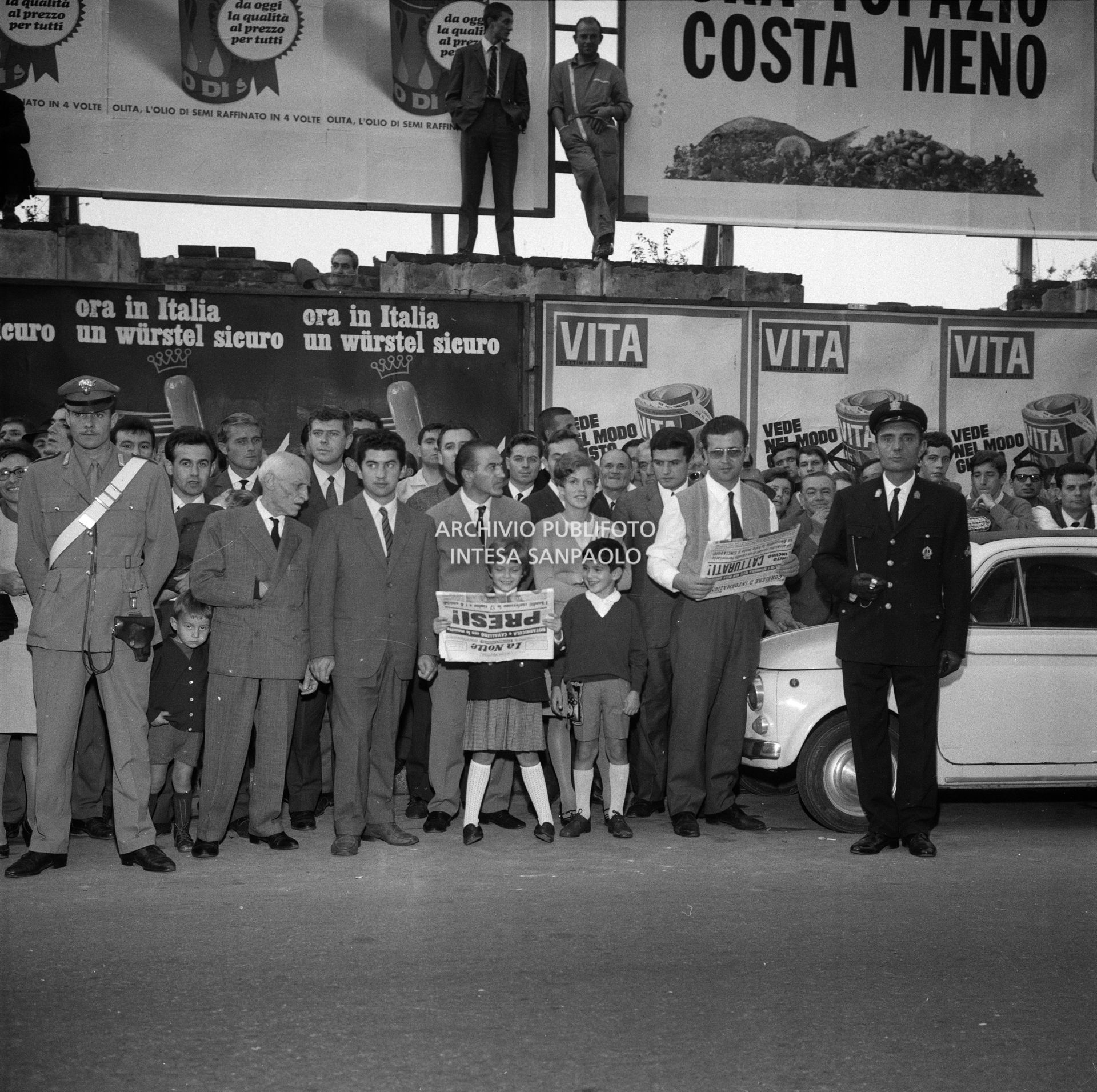 Gente in attesa della volante dei carabinieri con a bordo i due banditi Pietro Cavallero e Sante Notarnicola, davanti alla caserma di via della Moscova a Milano