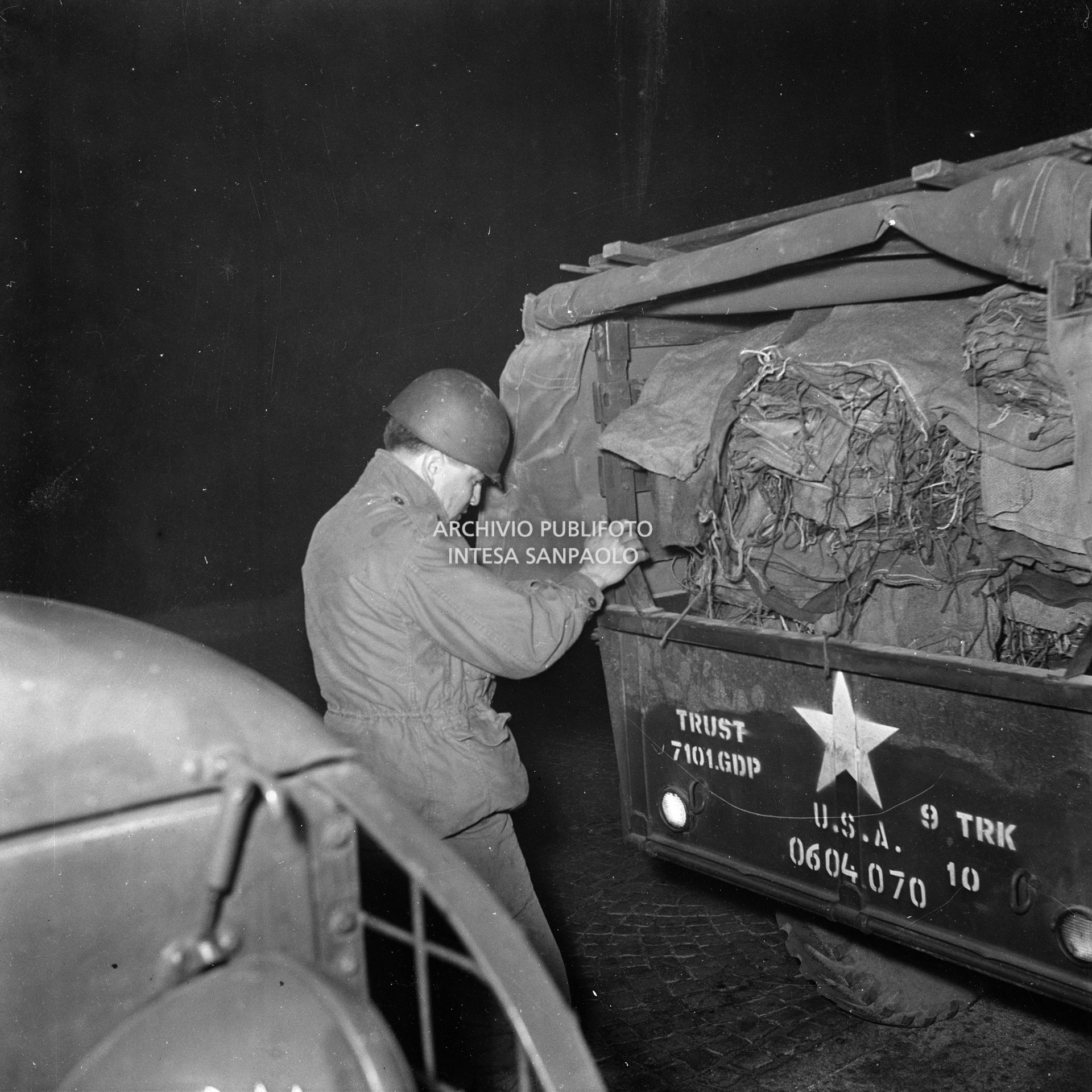 Un militare americano con materiale di soccorso, stipato su una jeep, per gli alluvionati del Polesine