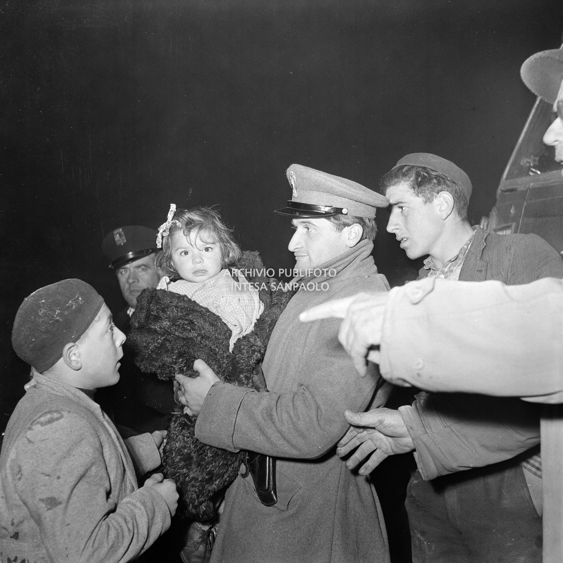 Un poliziotto tra gli alluvionati del Polesine, a Rovigo, tiene in braccio una bambina