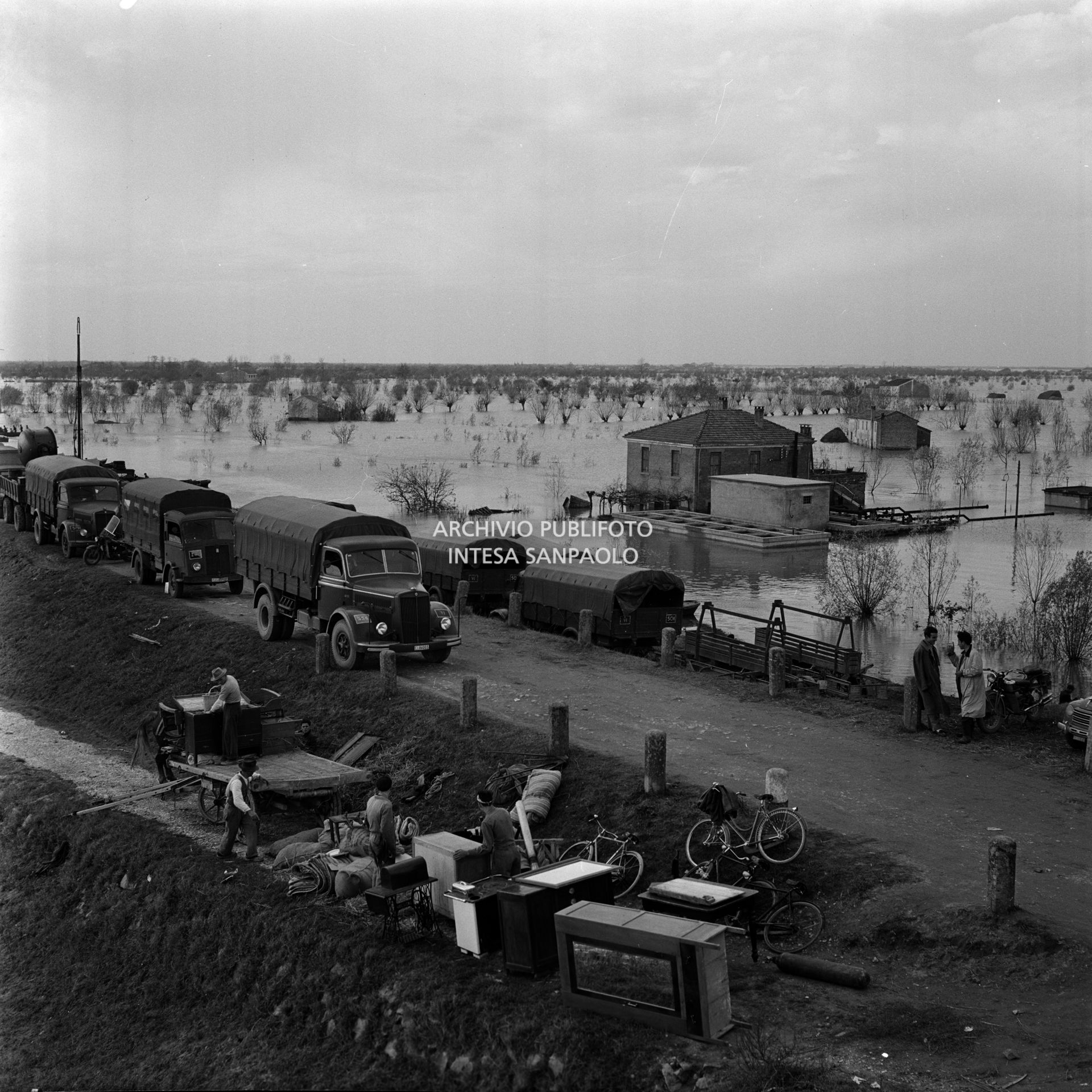 Masserizie degli alluvionati del Polesine accatastate a lato della strada, ingombra di mezzi di soccorso, nei pressi di Corbola