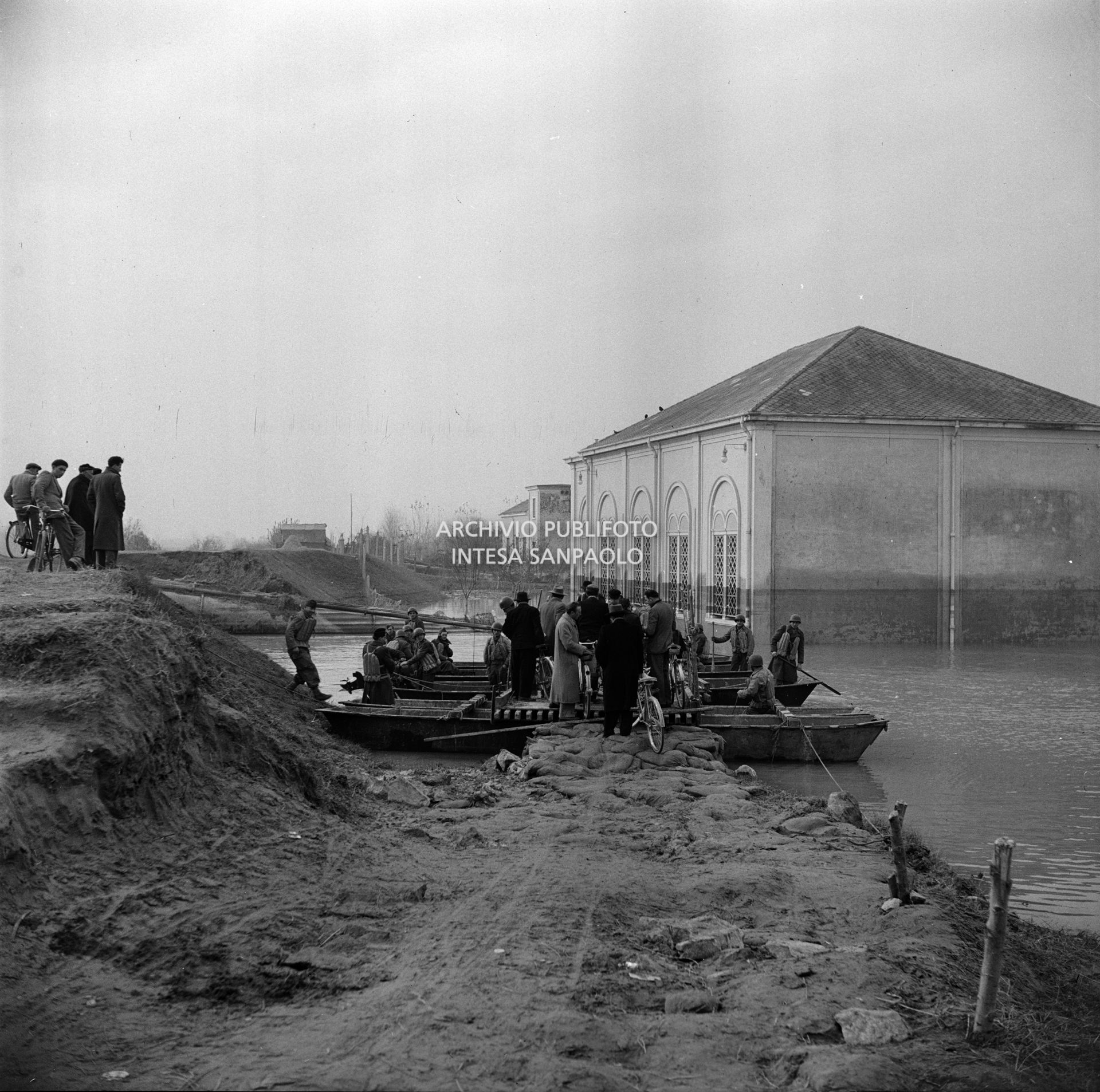 Militari e civili su imbarcazioni nei pressi dell'impianto idrovoro sul Canal Bianco nei giorni dell'alluvione del Polesine