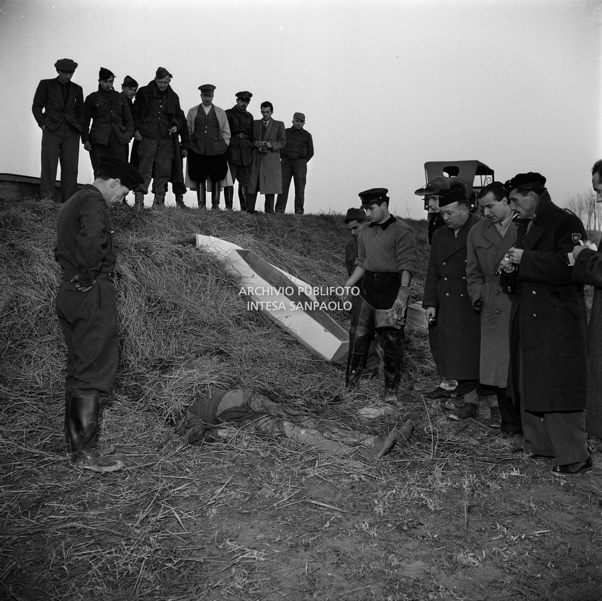 Militari osservano le salme delle vittime dell'alluvione del Polesine a Frassinelle